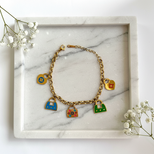 Gold Handbag Charm Bracelet flat lay on marble tray