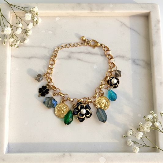 Gold Coin Flower Charm Bracelet flat lay on marble tray