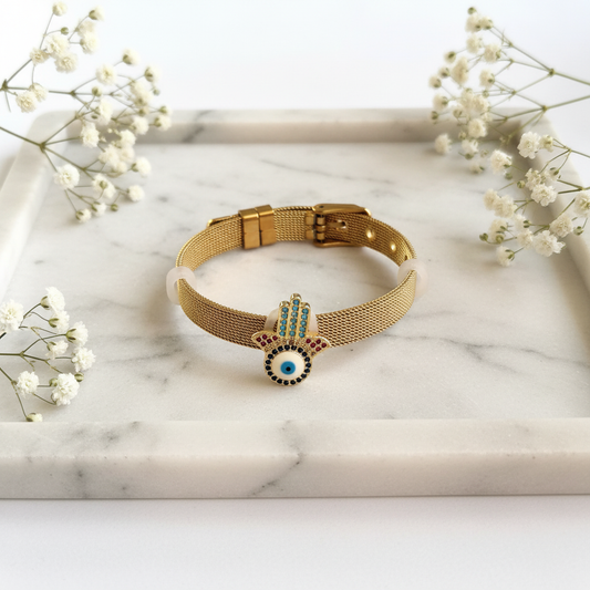 Gold Hamsa Evil Eye Bracelet flat lay on marble tray