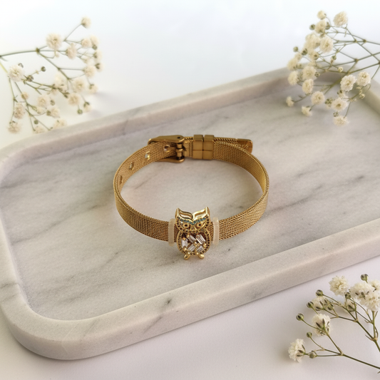 Gold Owl Bracelet flat lay on marble tray