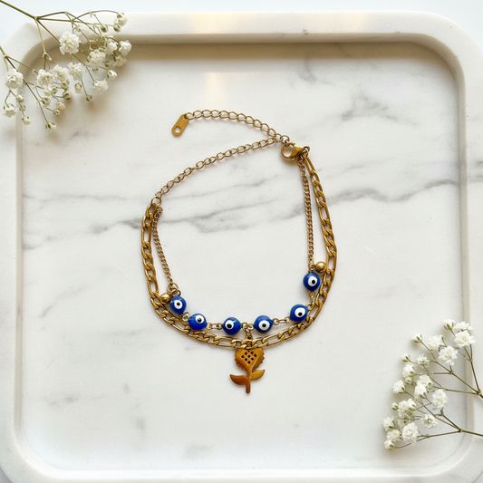 Gold Double Layer Evil Eye Rose Bracelet flat lay on marble tray